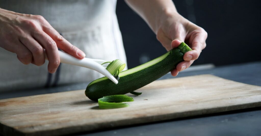 A personal chef cuts a vegetable as part of health meal prep at home.