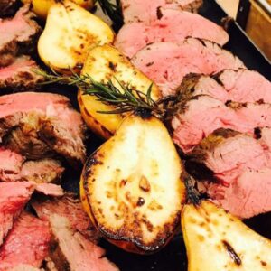 the image of a catering spread with meat and pears